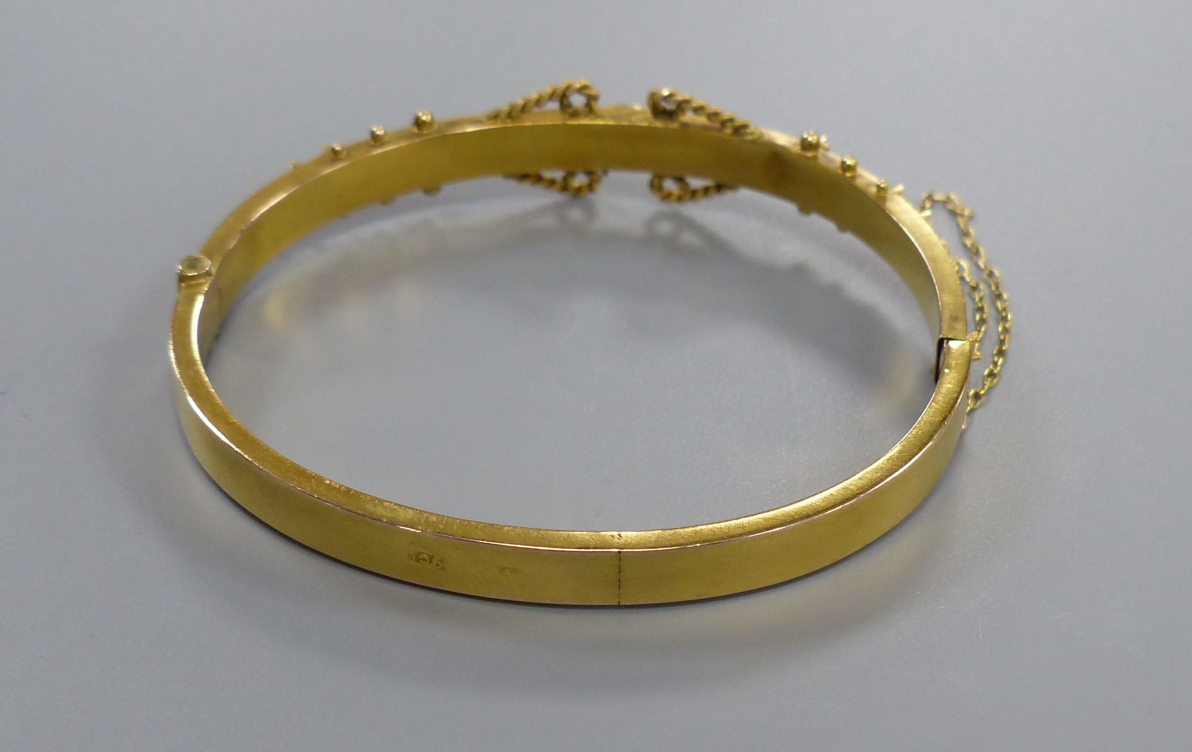 An Edwardian 9ct, sapphire and rose cut diamond chip set hinged bangle,